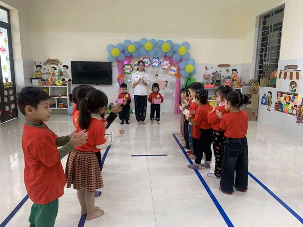 A group of children standing in a room

AI-generated content may be incorrect.