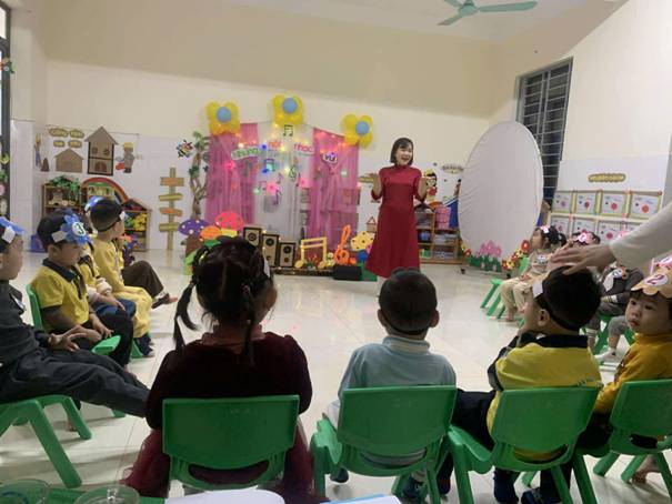 A person in a red dress standing in front of a group of children

AI-generated content may be incorrect.